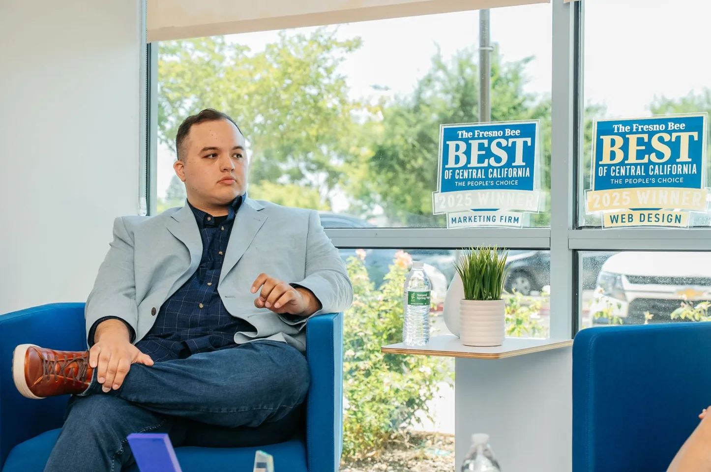 Aaron Marquez seated in the office beside the Fresno Bee awards.